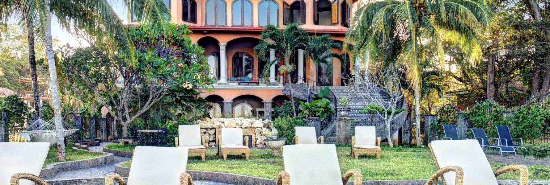 Three story rental home with bedding for 24 people on Playa Potrero, Guanacaste.  This Villa has eight chaise lounge chairs, hammock, and additional outdoor seating in a gorgeous tropical setting directly on the beach.