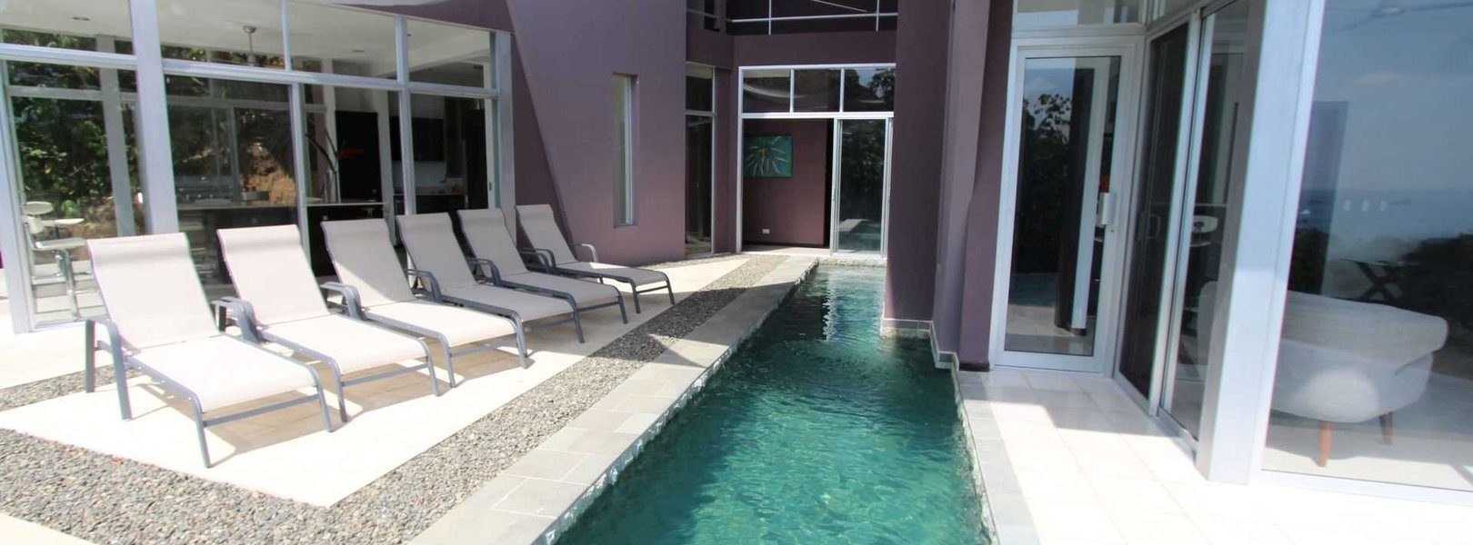 This modern vacation rental in Manuel Antonio features an infinity pool that partly cuts through the villa.