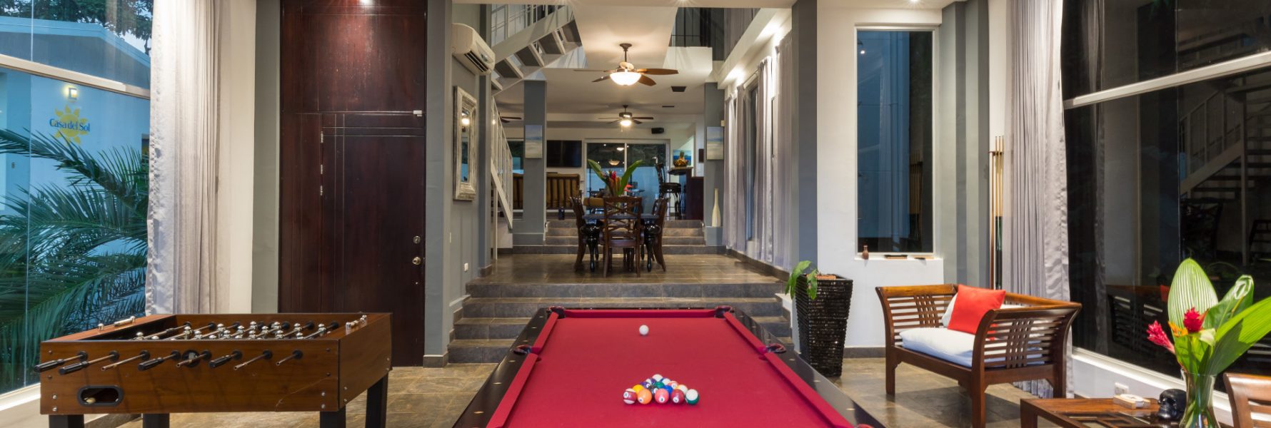 The game room features comfy seating, a pool table, foosball table, and breathtaking views.