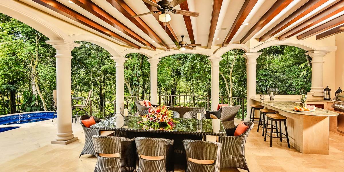 Spacious terrace overlooking the pool and verdant forest, perfect for alfresco dining.